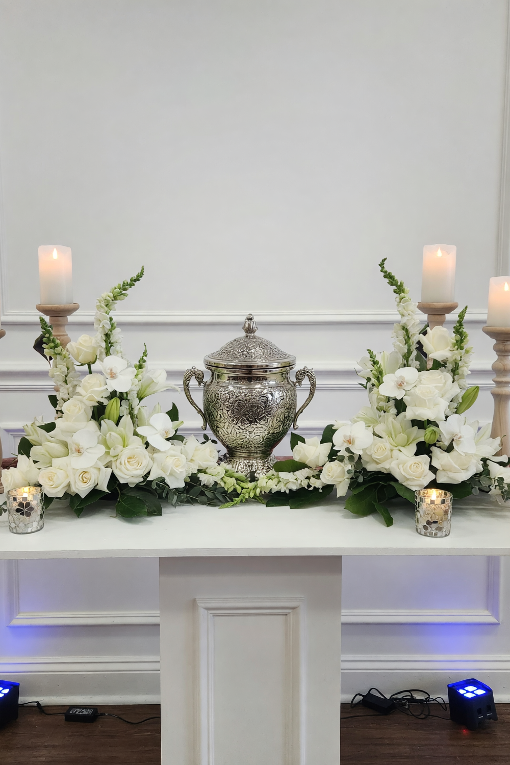 two white bouquets framing funeral urn