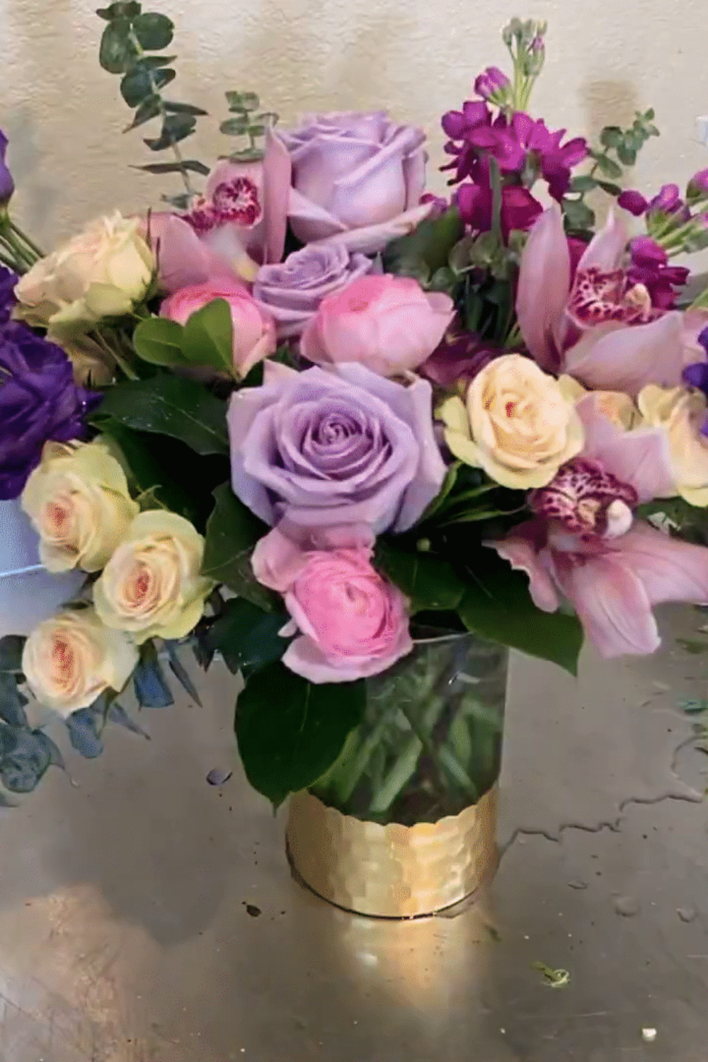 pretty pinks, lavenders, purples, magenta flowers designed in a vase.